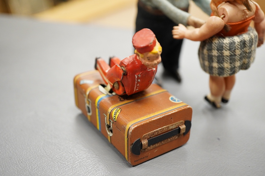 A Gescha, DRGM (Germany), clockwork tinplate acrobatic bellboy on ‘Express’ trunk, together with a Schuco, Germany tinplate and cellulose clockwork man with girl automaton